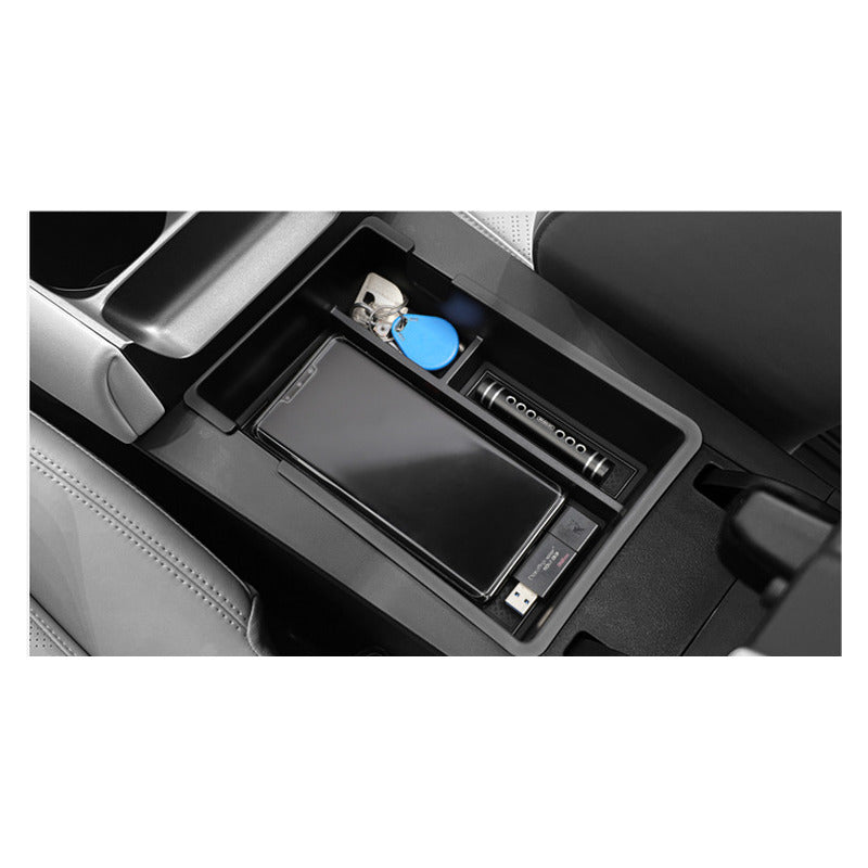 BYD Atto 2 armrest storage box in use, holding a phone and keys