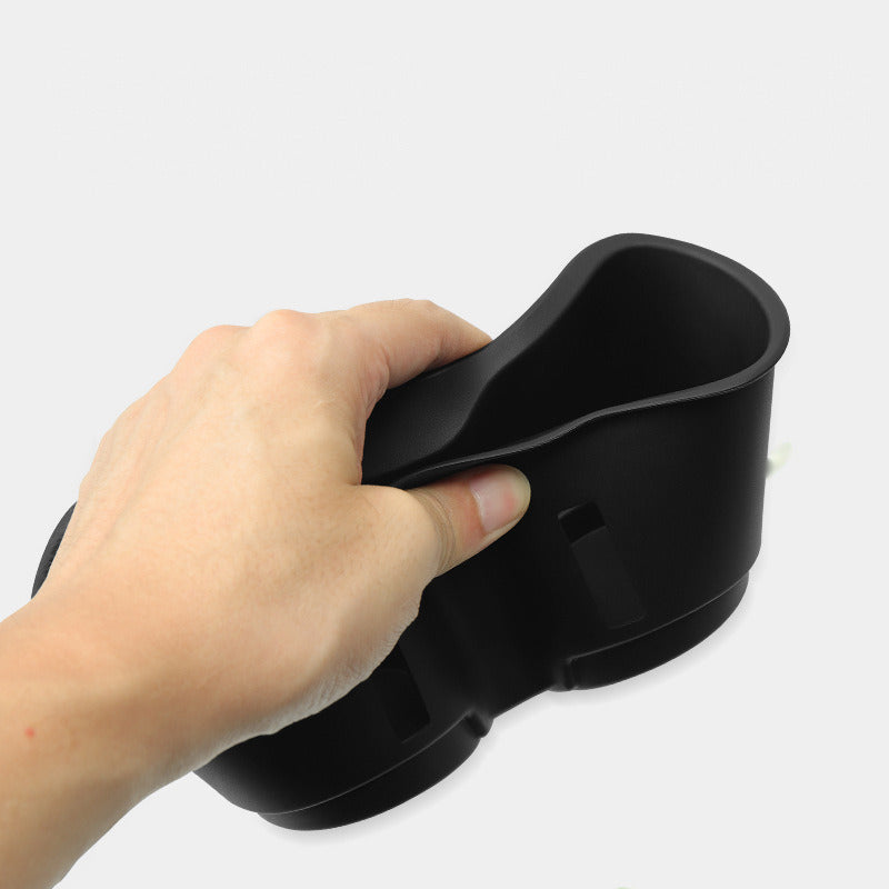 Cup holder insert squeezed by hand to show it is flexible