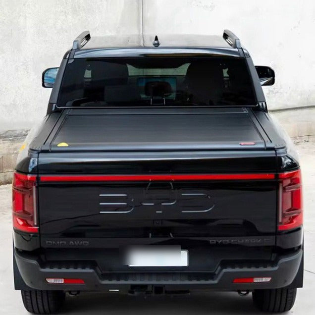 Electric roller lid tonneau cover on a black BYD Shark 6, rear view