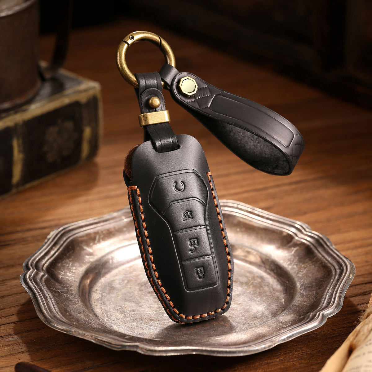 Black leather key pouch on a pewter plate